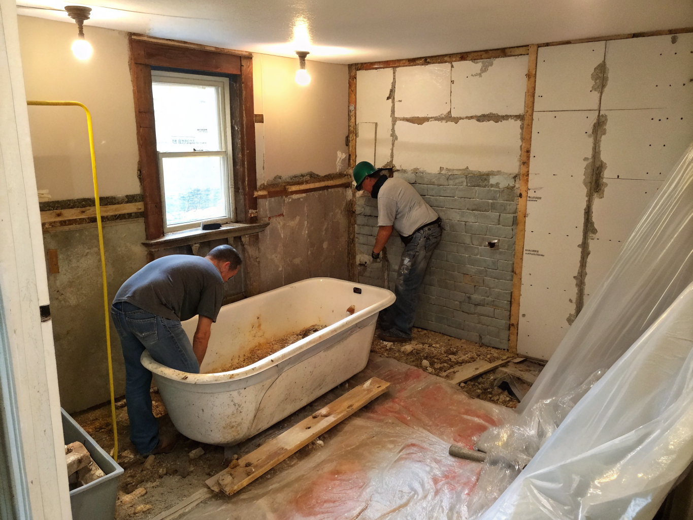 Workers removing cast iron bathtub during tub-to-shower conversion in Chicago