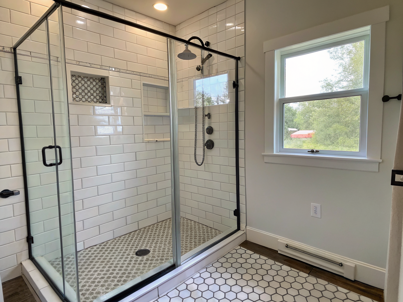 Finished tub-to-shower conversion with subway tile and frameless glass door